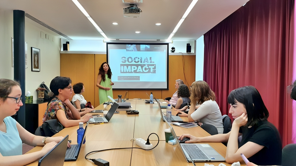Membres d'AccessCat miren els ordinadors mentre escolten una formadora