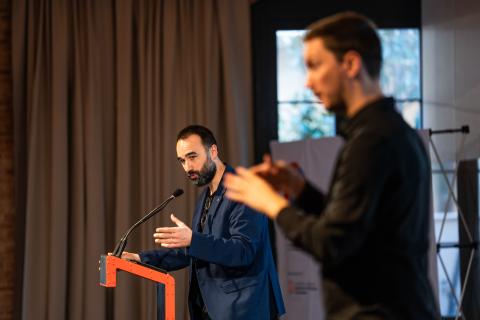 Javier Selva, parlant a un faristol. En primer pla, un intèrpret de llengua de signes catalana.